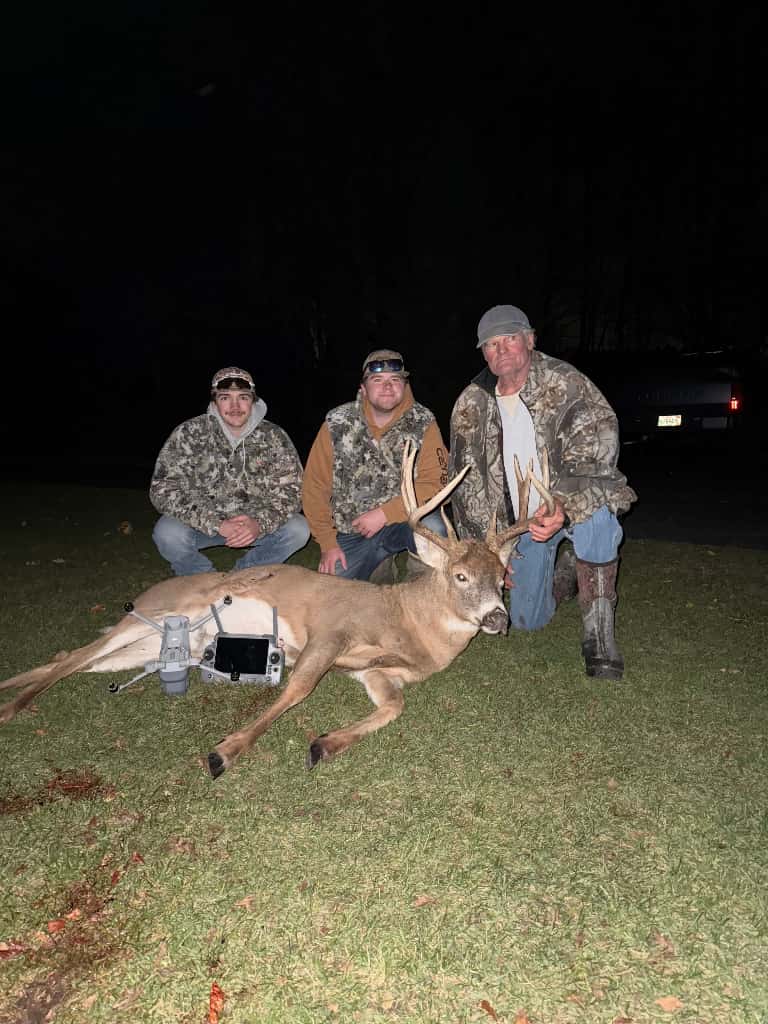 Hunters posing with a recovered whitetail deer after a successful drone-assisted deer recovery service in Wisconsin.