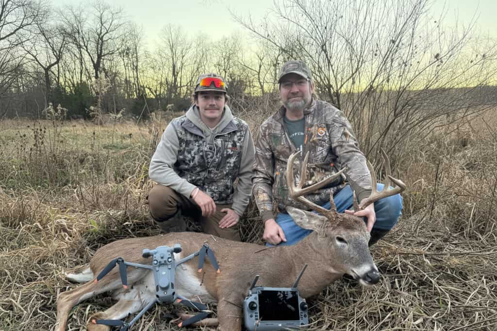 Two hunters posing with a recovered whitetail buck and drone equipment after a successful drone deer recovery in Wisconsin by Wisco Drone Co.